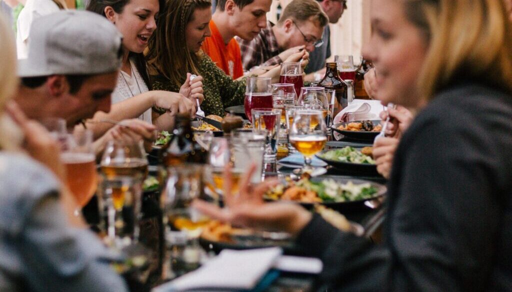 people sitting in front of table talking and eating