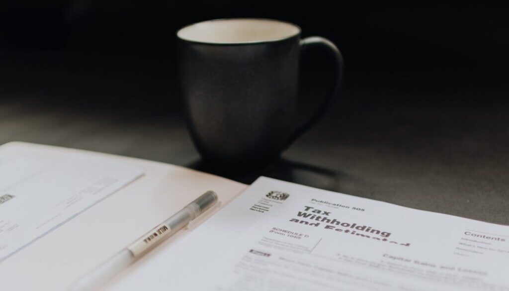 coffee mug near open folder with tax withholding paper