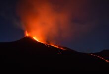 black mountain with flowing lava at nighttime