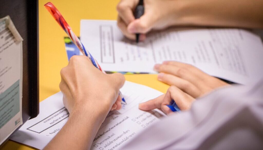 person writing on white paper