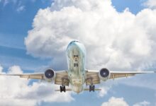 gray and white airplane on flight near clear blue sky