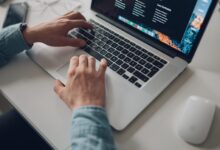 person wearing long-sleeve top working on laptop