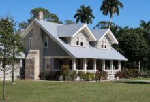 brown and white concrete house near green grass field during daytime