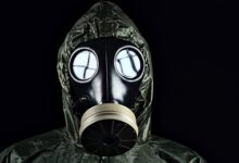 person in green and black gas mask