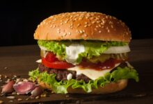 hamburger with vegetables on wooden surface