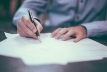man writing on paper