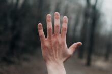 shallow focus photography of person's left hand outside