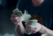 focus photography of person counting dollar banknotes