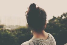focus photography of woman facing trees