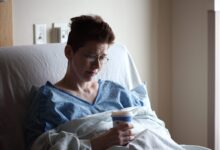 woman on bed holding plastic cup