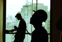 two men wearing hard hat standing near clear glass window