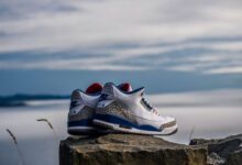 pair of white-and-blue Air Jordan 2's on rock fragment