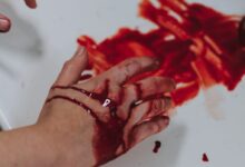 person holding red and silver round ornament