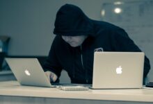 man in black hoodie using macbook