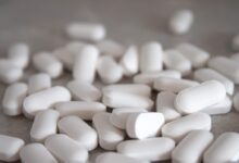 white medication pills on brown surface