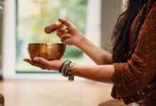 woman in brown knit sweater holding brown ceramic cup