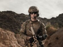 man in brown and black camouflage uniform holding rifle