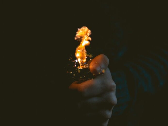 person holding lighted lighter