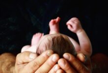 person holding babys hand