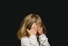 girl covering her face with both hands