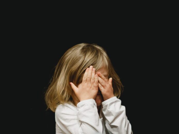 girl covering her face with both hands