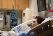 boy lying on beige recliner hospital bed