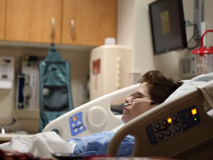 boy lying on beige recliner hospital bed