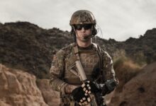 man in brown and black camouflage uniform holding rifle