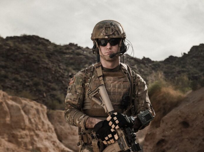 man in brown and black camouflage uniform holding rifle