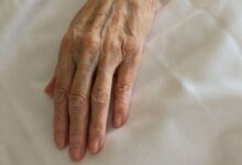 persons left hand on white textile