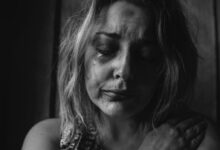 grayscale photo of woman crying holding her right chest
