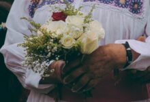 person holding bouquet of yellow roses