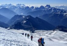 people hiking on snow covered mountain during daytime