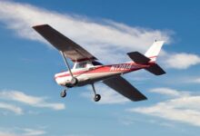 red and white airplane flying in the sky during daytime