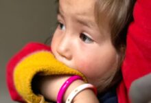 child in red and yellow knit cap