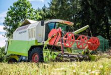 red and yellow heavy equipment on green grass field during daytime