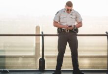 cop leaning on metal rail during a sunny day