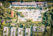 aerial photography of brown gray concrete buildings surrounded by trees