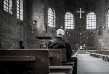 person sitting on pew inside church
