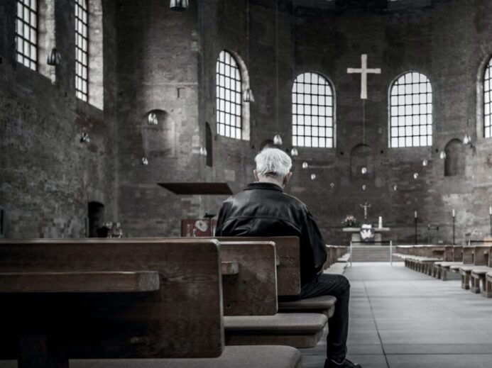 person sitting on pew inside church