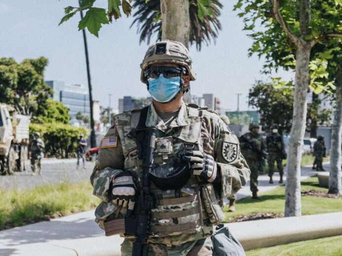 man in green and brown camouflage uniform holding brown rifle