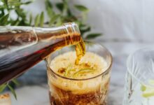 clear drinking glass with ice and brown liquid
