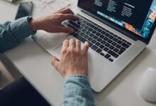 person wearing long-sleeve top working on laptop