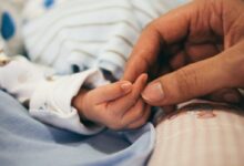 person holding baby's index finger