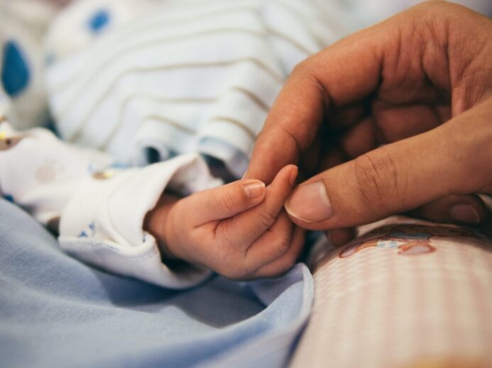 person holding baby's index finger
