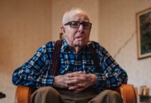 man wearing brown trousers sitting on sofa chair