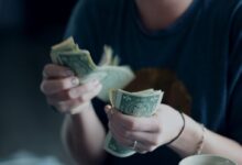 focus photography of person counting dollar banknotes