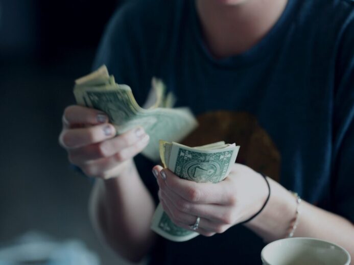 focus photography of person counting dollar banknotes