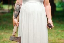 woman in white dress holding axe during daytime