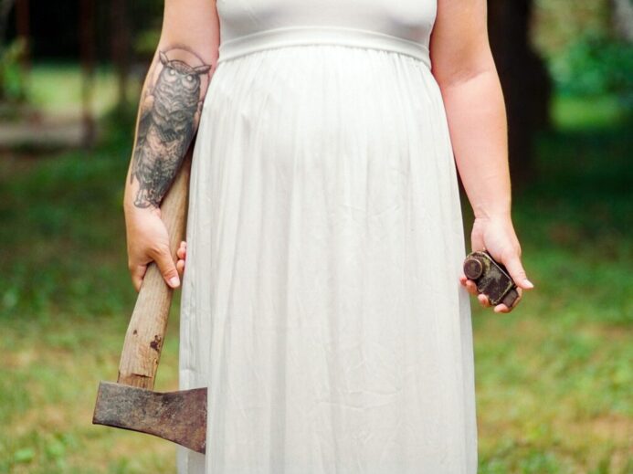 woman in white dress holding axe during daytime